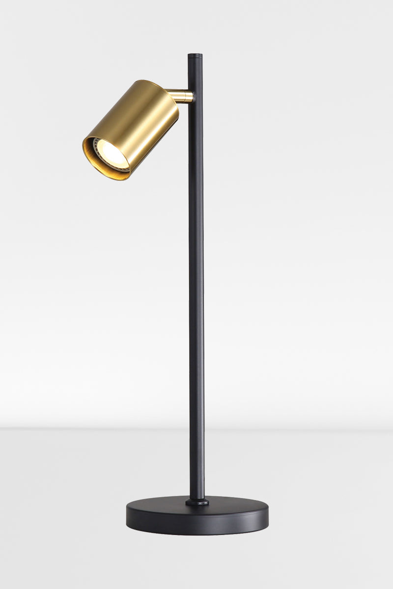 Black desk lamp with satin brass spot headand light on. 