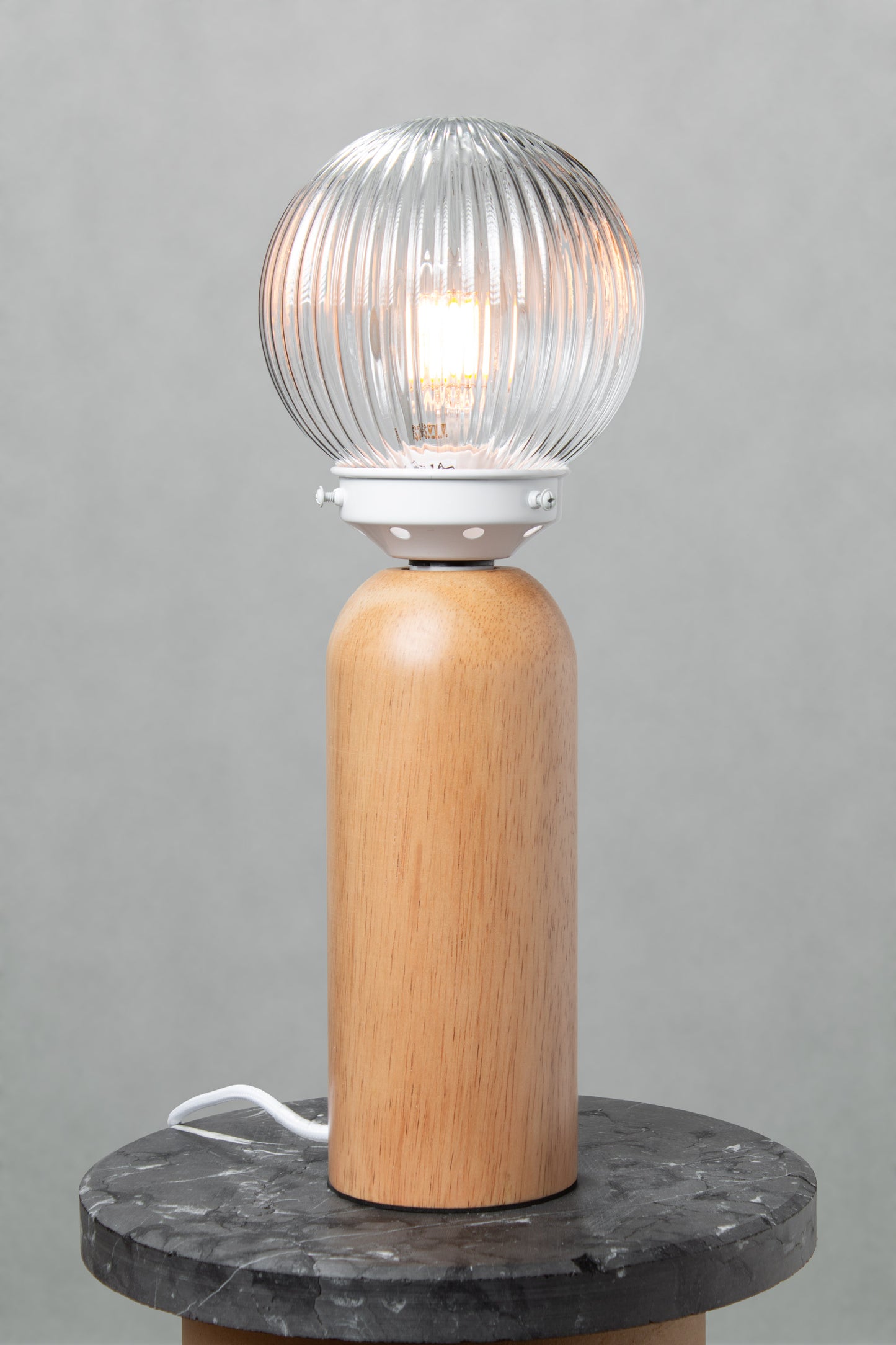 Dakota Wood Table Lamp with clear reeded glass shade illuminated