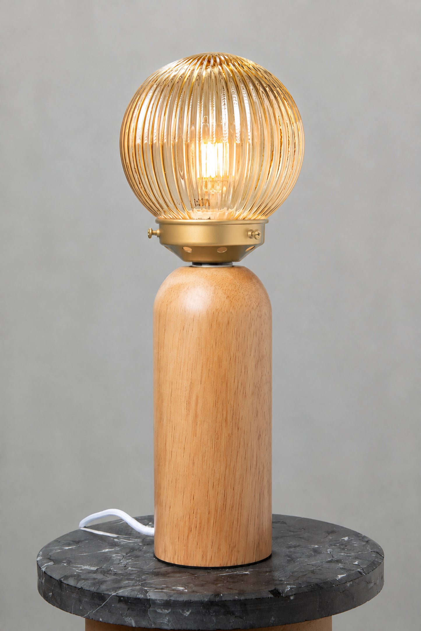Dakota Wood Table Lamp with amber reeded glass shade illuminated