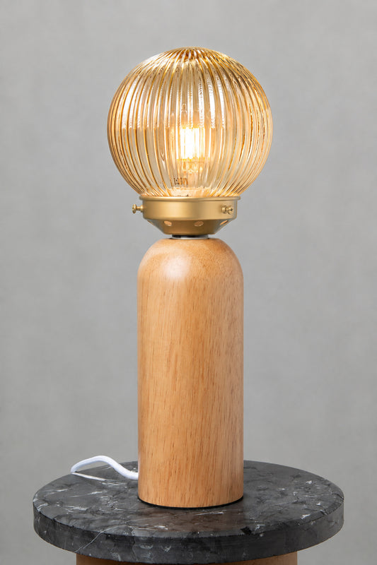 Dakota Wood Table Lamp with amber reeded glass shade illuminated