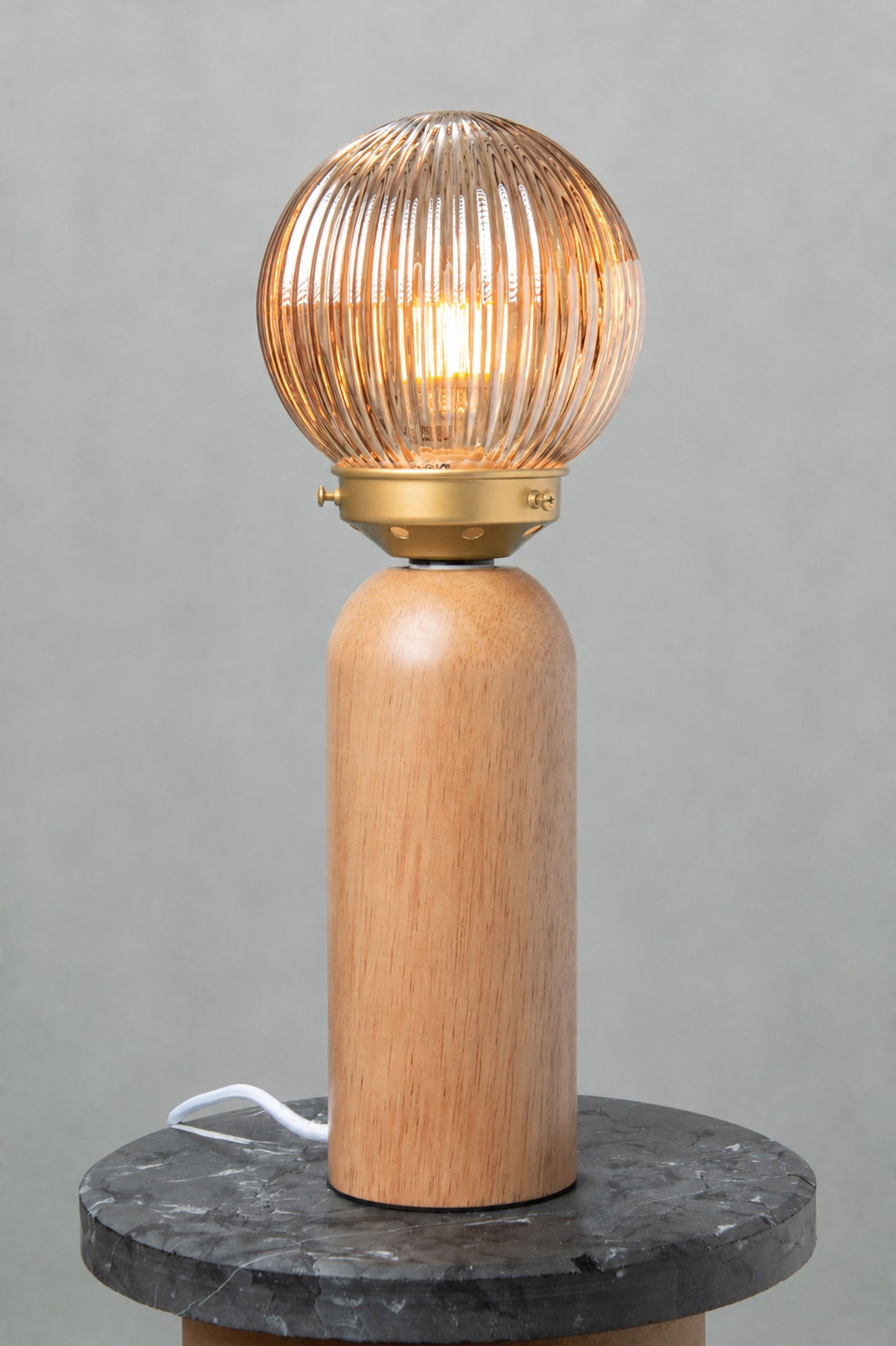Dakota Wood Table Lamp with dark amber reeded glass shade illuminated