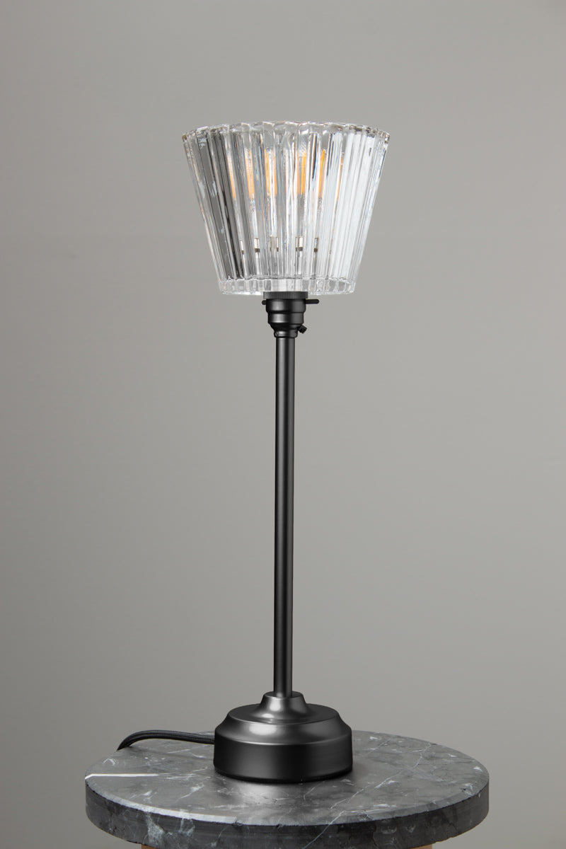 Davis Glass Candlestick Table Lamp in Black on a marble table.