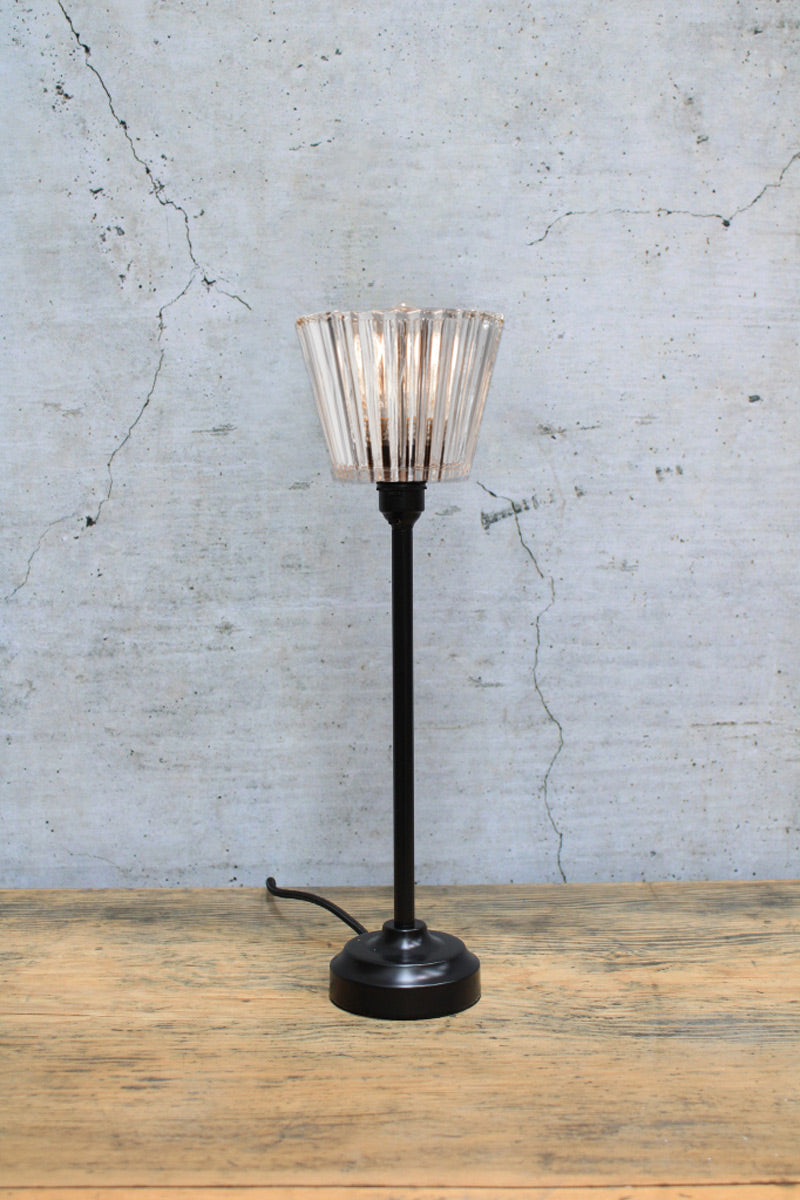 Black Candlestick lamp base paired with the Davis clear glass shade on a timber bench. 