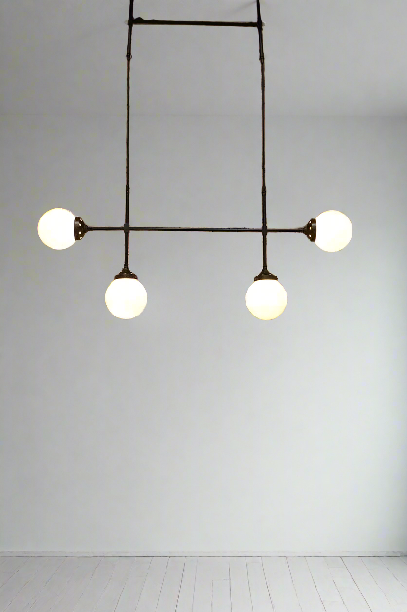 The glass ball junctin pendant light is a hand assembled frame made from quality brass