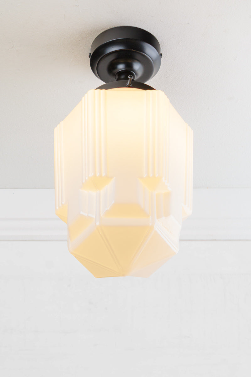 Art Deco inspired geometric opal glass shade paired with a close to ceiling  batten holder in black. 