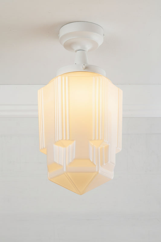 Large geometric opal glass shade with art deco influence, paired with a white batten holder. 