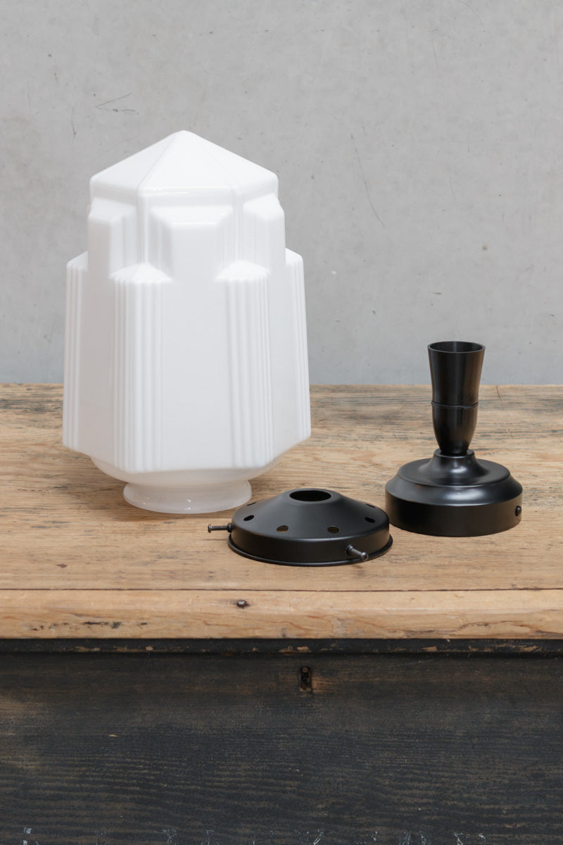 Large Art Deco inspired opal glass shade, sitting on a timber bench with a black gallery and batten holder. 