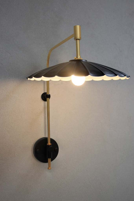 Umbrella wall lamp with gold/brass wing arm with large black shade.