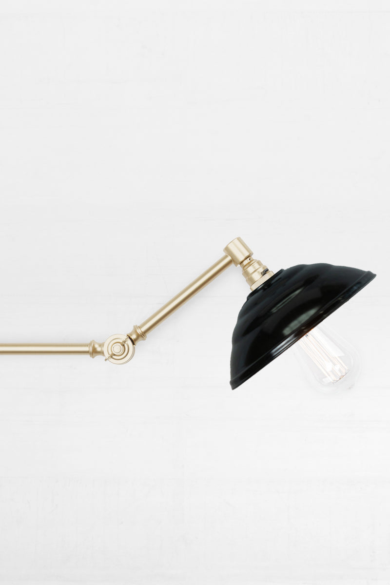 Swing Arm Wall Lamp in gold arm finish with black Bakelite shade