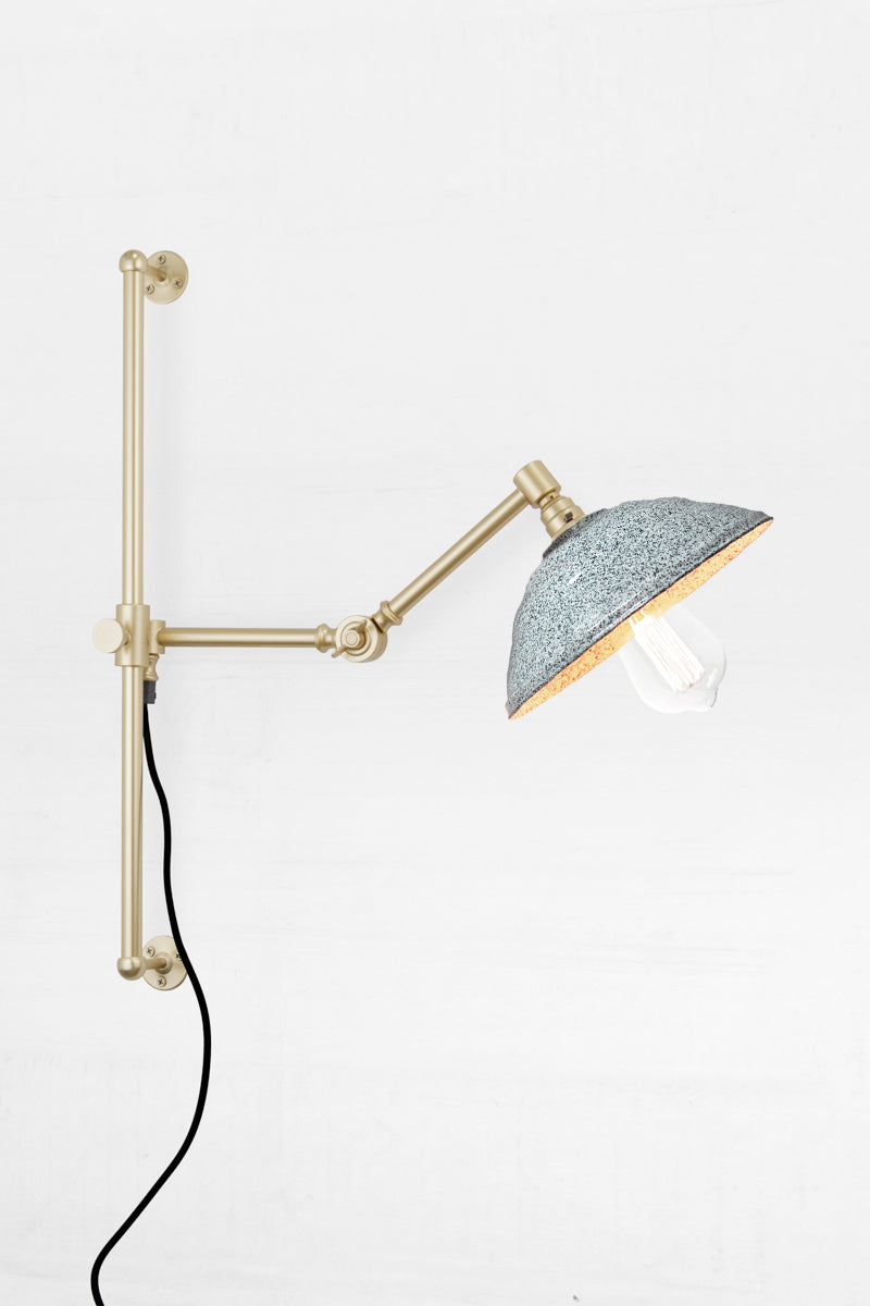 Swing Arm Wall Lamp in gold/brass arm finish with white/black Bakelite shade 