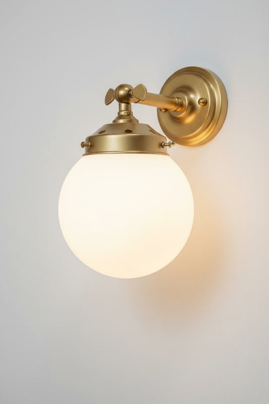 Small opal glass ball shade on a short gold/brss wall sconce