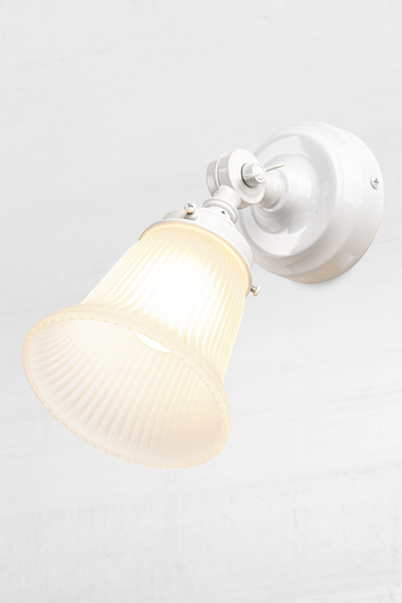 Slightly extended adjustable wall batten in white with a small opal glass shade with ribbed detailing.