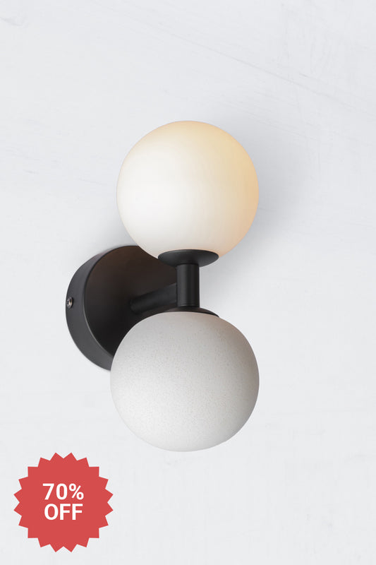 Modern wall sconce with black metalware opal glass ball shade and concrete ball feature.