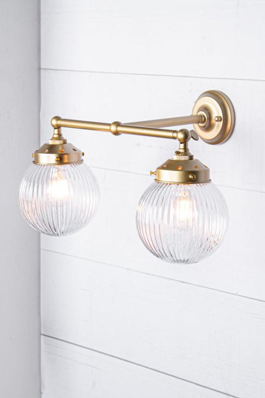 gold brass arm sconce with clear shade