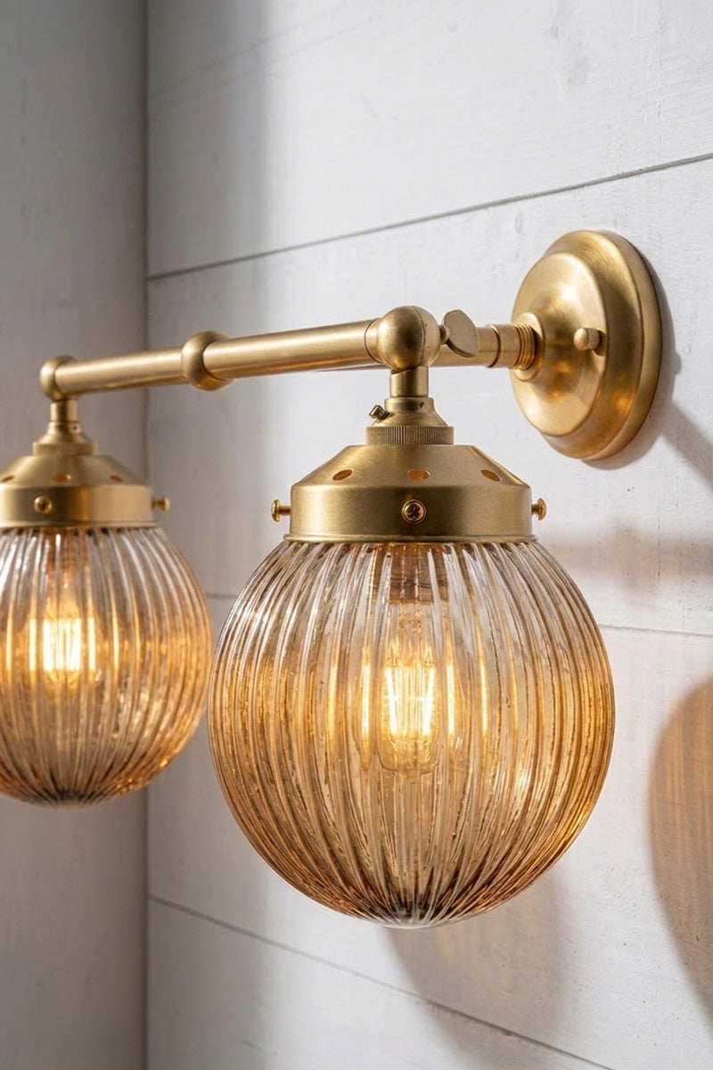 Close up of the Gold/Brass double arm sconce with dark amber shades.