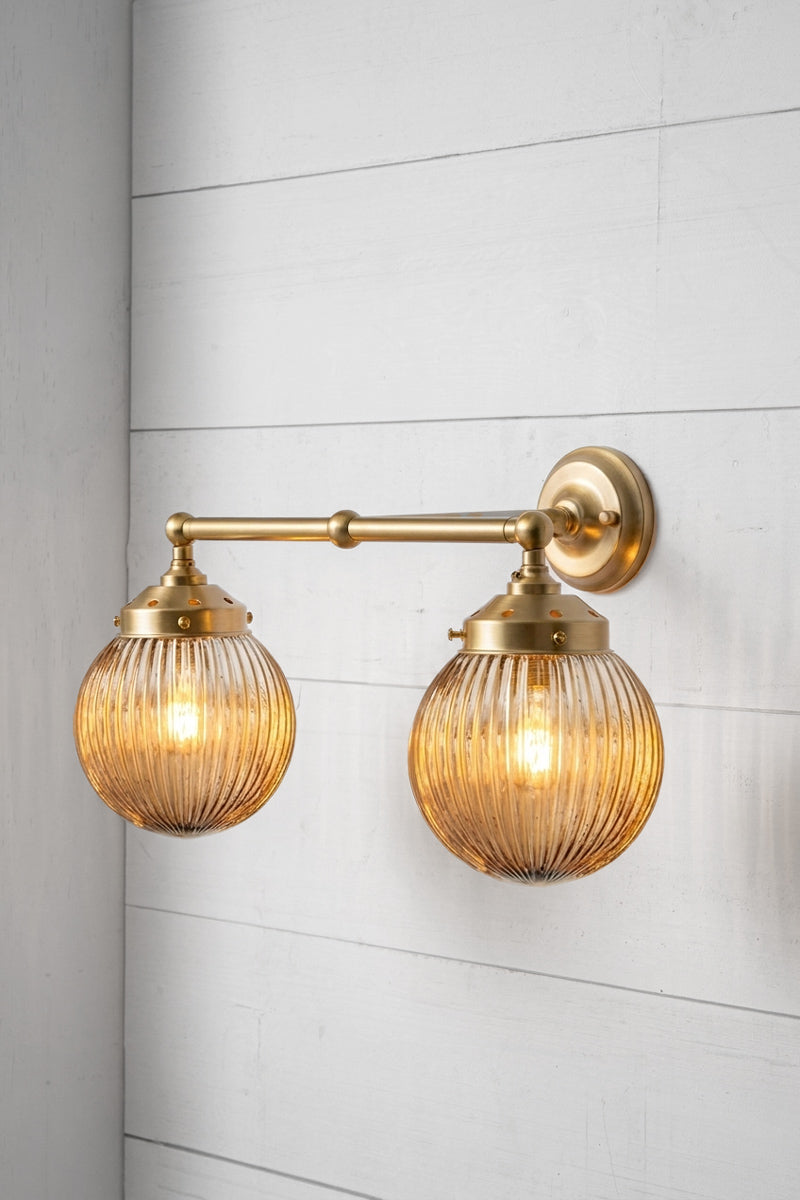 Gold/Brass double arm sconce with dark amber shades.