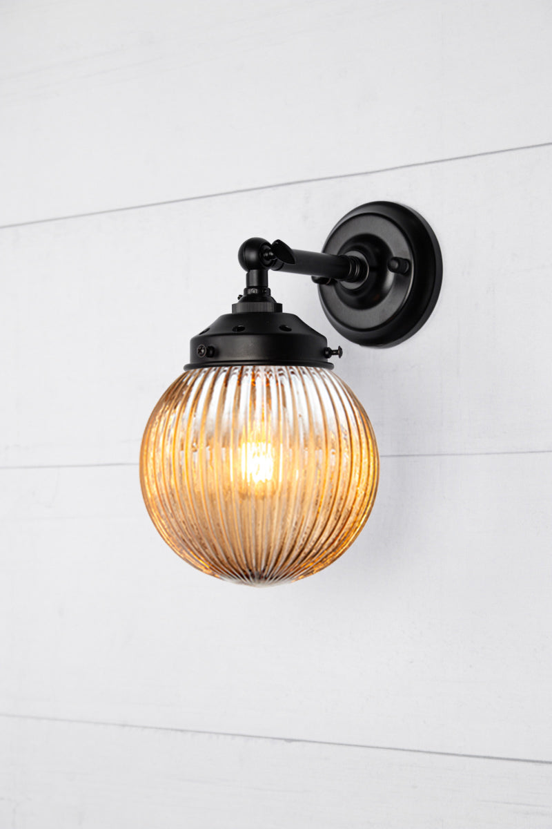 Dark amber glass reeded ball shade on a short black swivel straight arm.