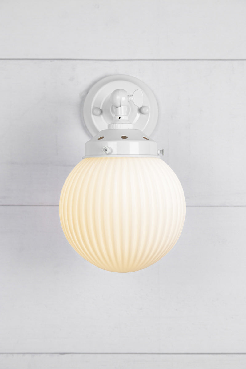 Opal glass reeded ball shade on a short whiteswivel straight arm.