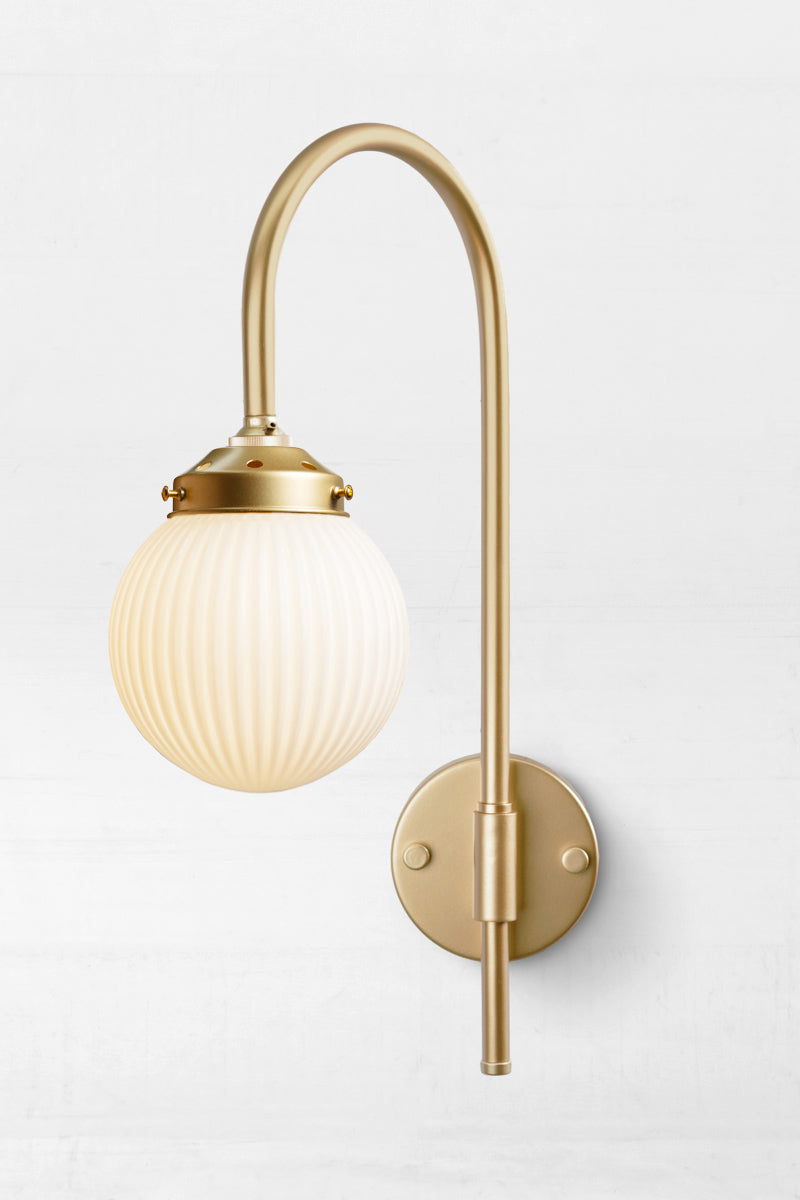 Shepard gooseneck wall light in gold/brass with an opalreeded glass ball shade. 