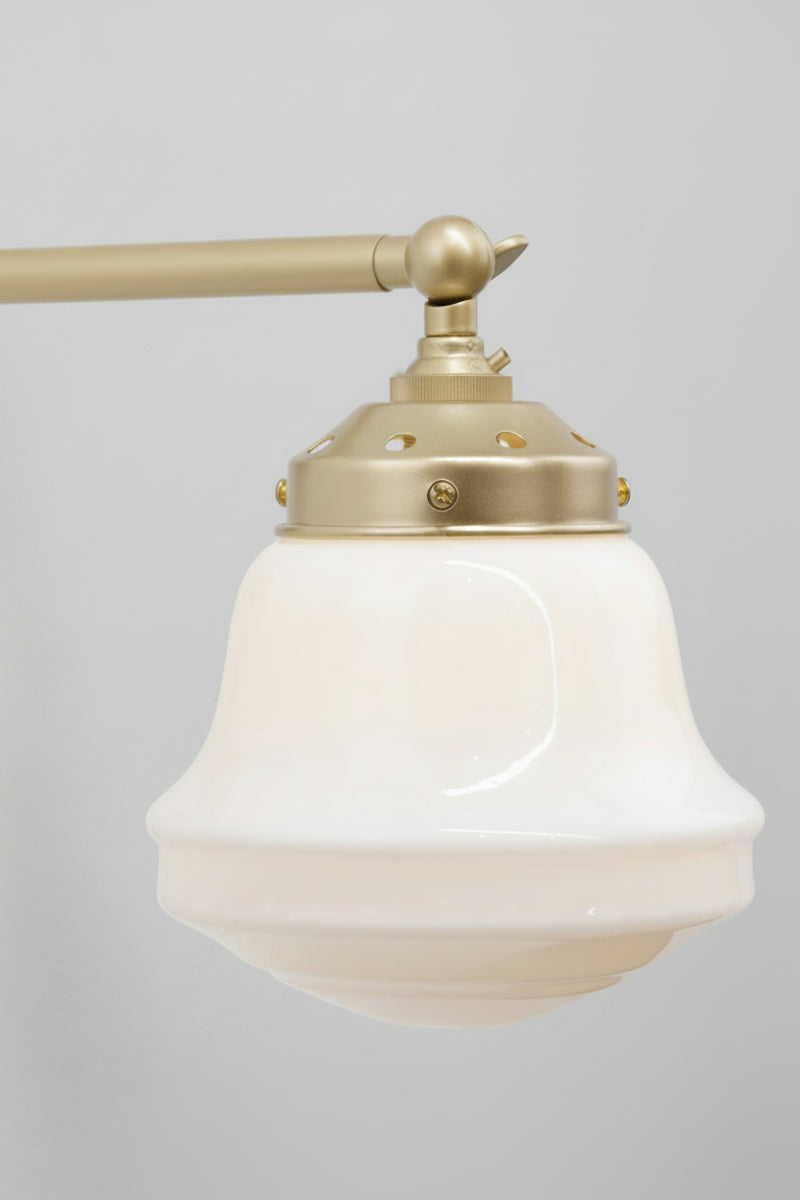Close up of the gold/brass arm with opal glass schoolhouse style shade. 