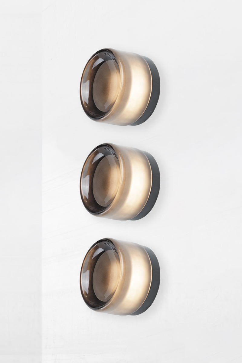 Side angle image of smoked grey Laval Dimple Glass LED Wall Sconce triple configuration with sculptural layered glass detail.