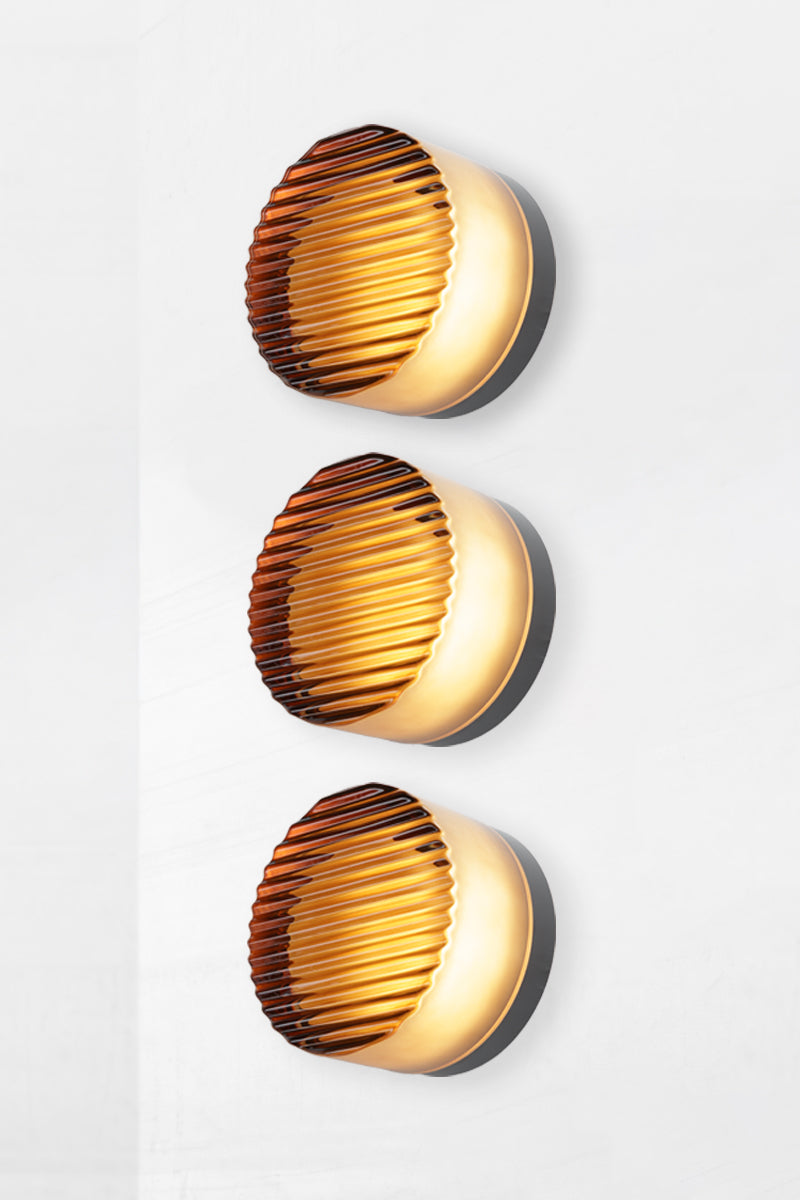 Side angle image of triple amber Laval Dimple Glass LED Wall Sconce configuration showing textured ribbed glass detail and black circular backplates.