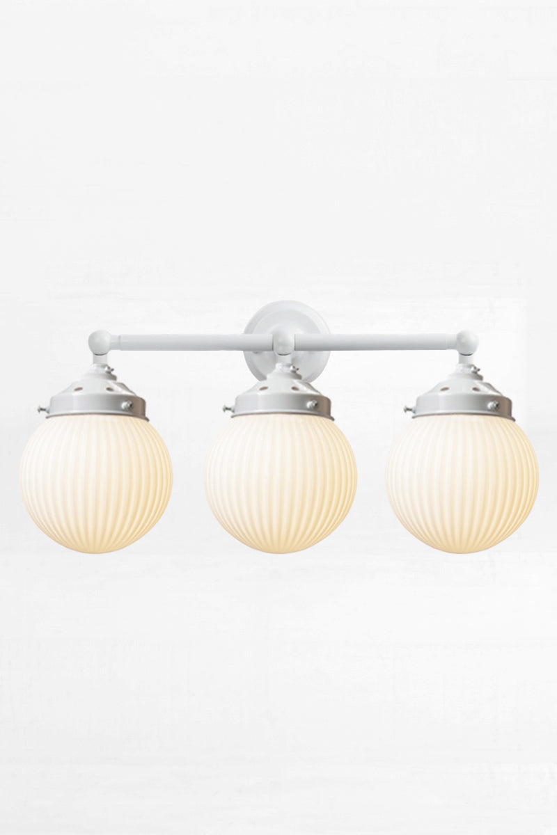 White three lampholder wall sconce paired with three opal reeded glass ball shades. 