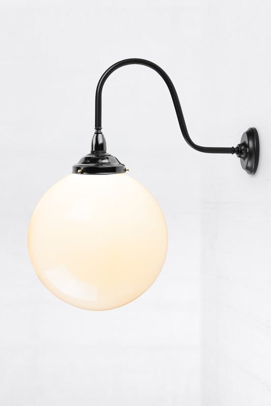 Side view of the extra large gooseneck wall sconce in black with a large opal glass ball shade. 