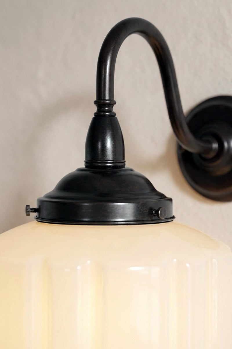 Close-up of Deco Glass Exterior Wall Light with black curved arm and opal glass shade