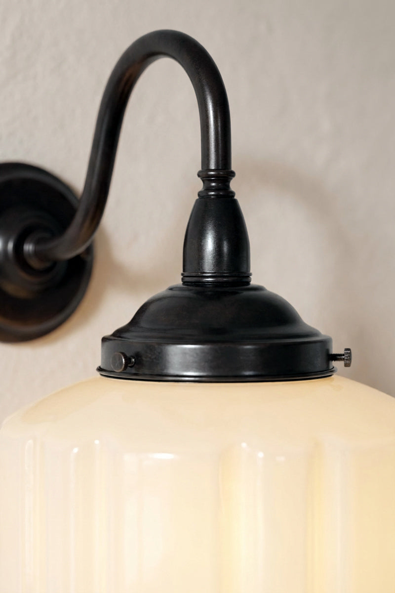 Close-up of Deco Glass Exterior Wall Light with black curved arm and opal glass shade