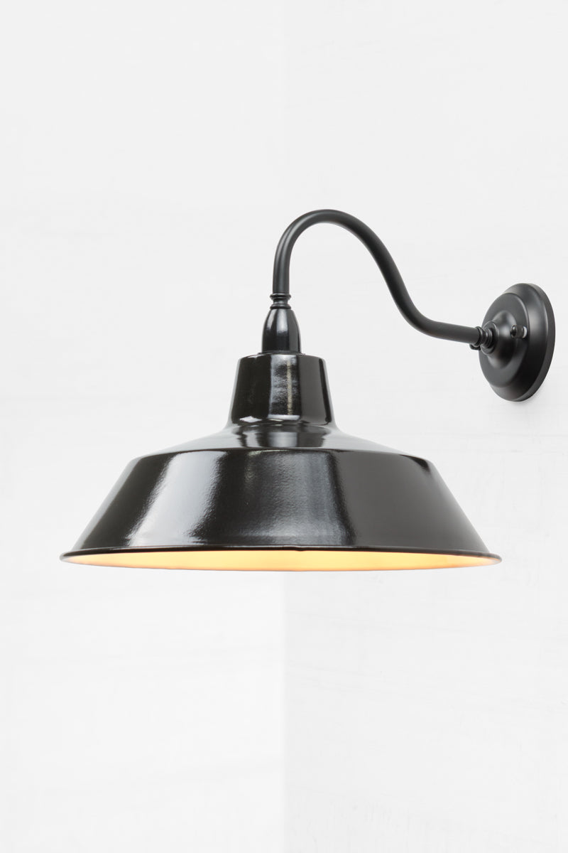 Exterior wall sconce with a black gooseneck arm and large shade. 
