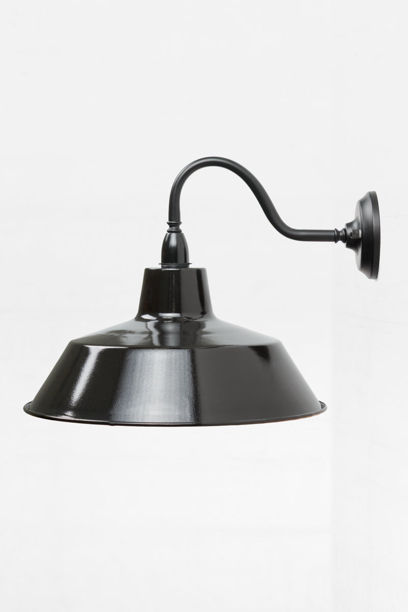 Side view of the exterior wall sconce with a black gooseneck arm and large shade. 