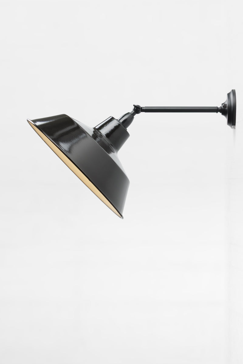 Long straight Arm outdoor wall sconce showing the swivel lampholder and a black steel shade. 