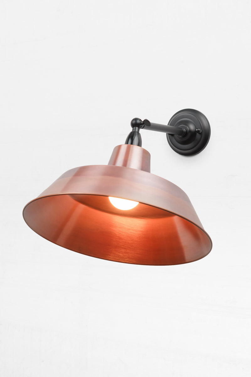 Long straight Arm outdoor wall sconce with a swivel lampholder and a Bright Brass solid copper shade. 
