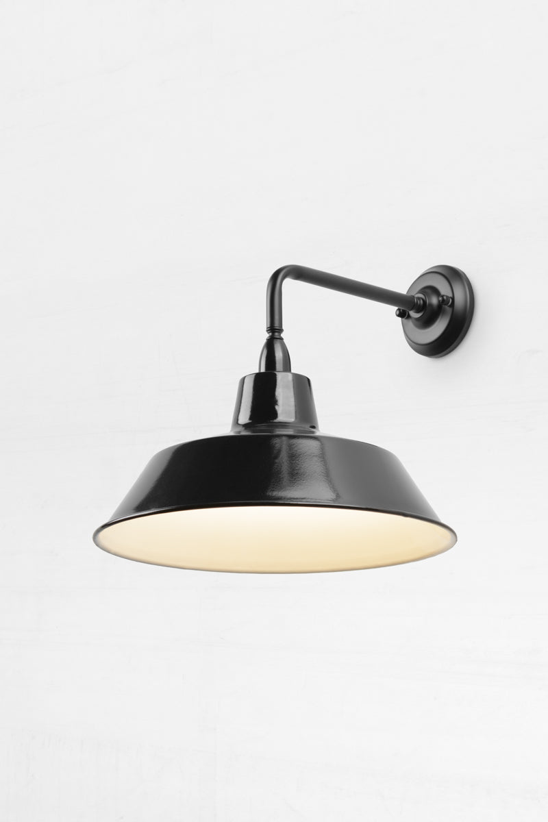 90 Degree outdoor wall sconce with a Black steel shade, that has a white inner.  
