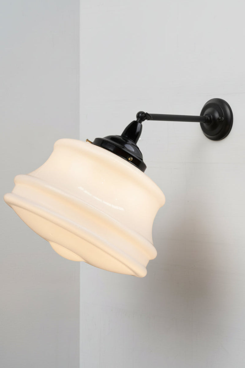 Schoolhouse style shade paired with a steel long arm tiltable wall sconce in black