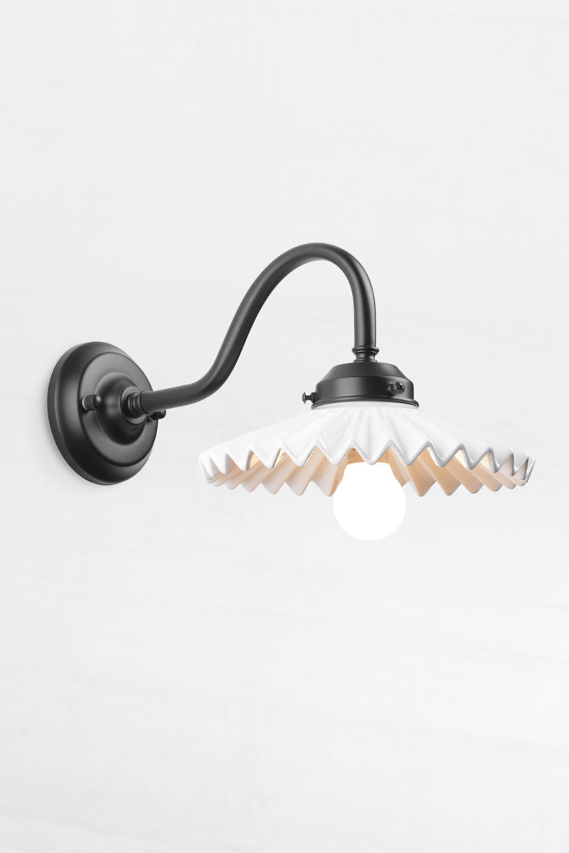 Black gooseneck wall arm with an integrated 2 and 1/4 cup, paired with a white ceramic shade. 