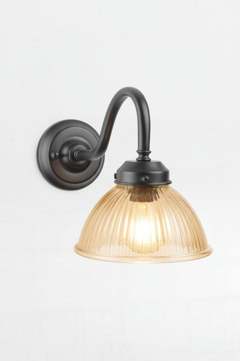 Amber ribbed glass shade on a black outdoor gooseneck wall light