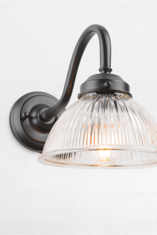 Close up of the ribbed shade on the black outdoor gooseneck wall light.