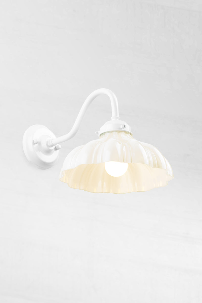 White gooseneck wall sconce with integrated gallery, paired with an opal glass shade and opaal bulb.