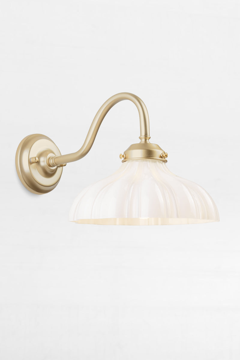 Gold/brass gooseneck wall sconce with integrated gallery, paired with an opal glass shade with vintage detailing.