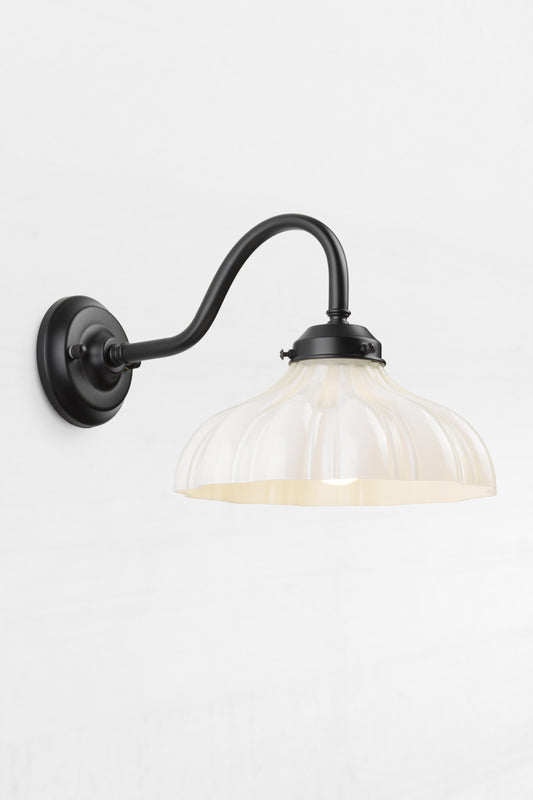 Black gooseneck wall sconce with integrated gallery, paired with an opal glass shade with vintage detailing.