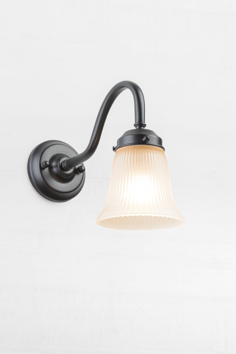 Golde/brass gooseneck wall sconce with integrated gallery and a small opal ribbed glass  shade. 