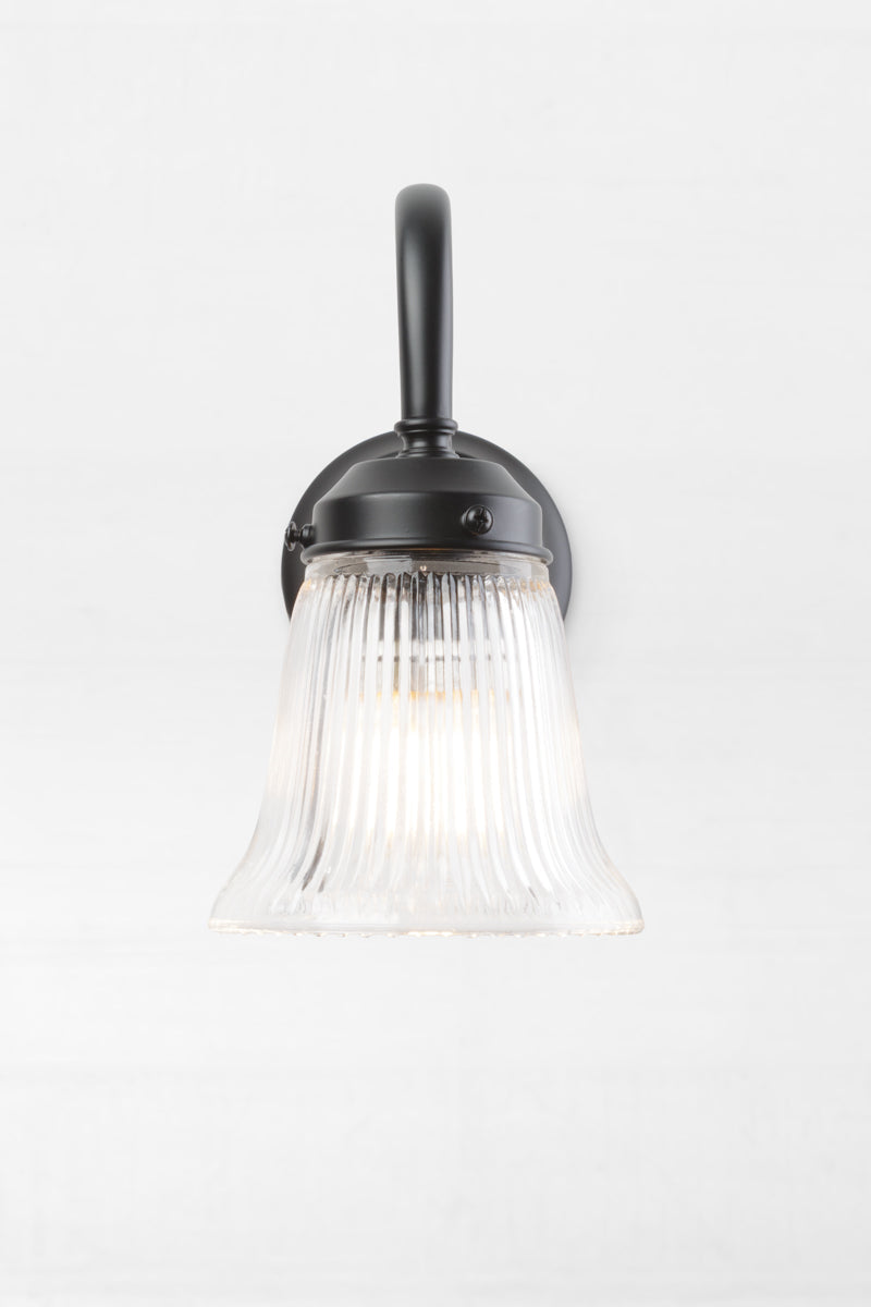 Front on view of the black gooseneck wall sconce clear ribbed glass  shade. 