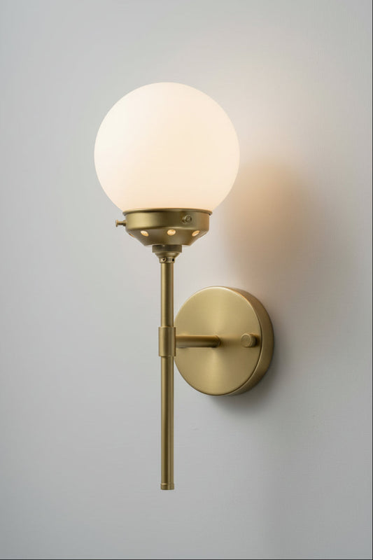Gold brass steel stem wall sconce paired with an opal glass ball shade