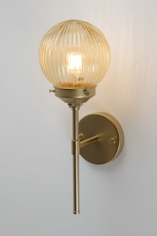 Reeded glass ball shade in amber with a gold/brass stem wall ssconce