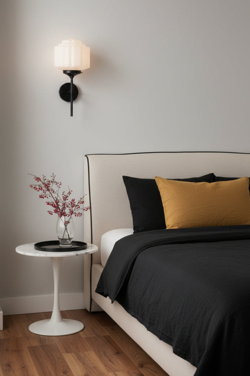 Opal Deco glass shade on a black wall sconce as a bedside light next to a classically styled elegant bedroom space. 