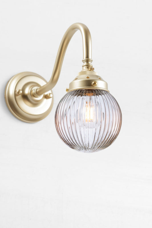 Gold/brass gooseneck wall sconce with a clear reeded glass ball shade. 