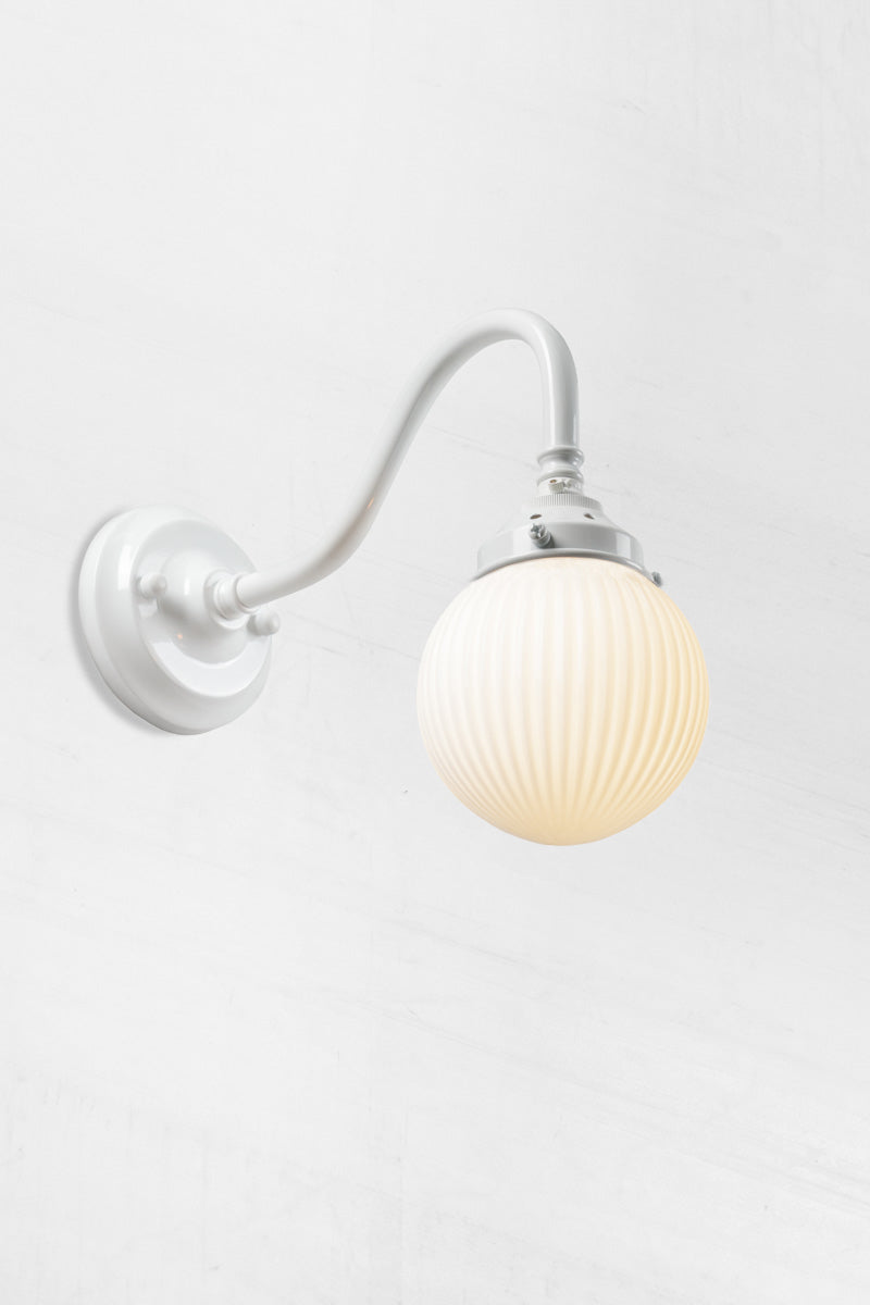 White gooseneck wall sconce with an opal reeded glass ball shade. 