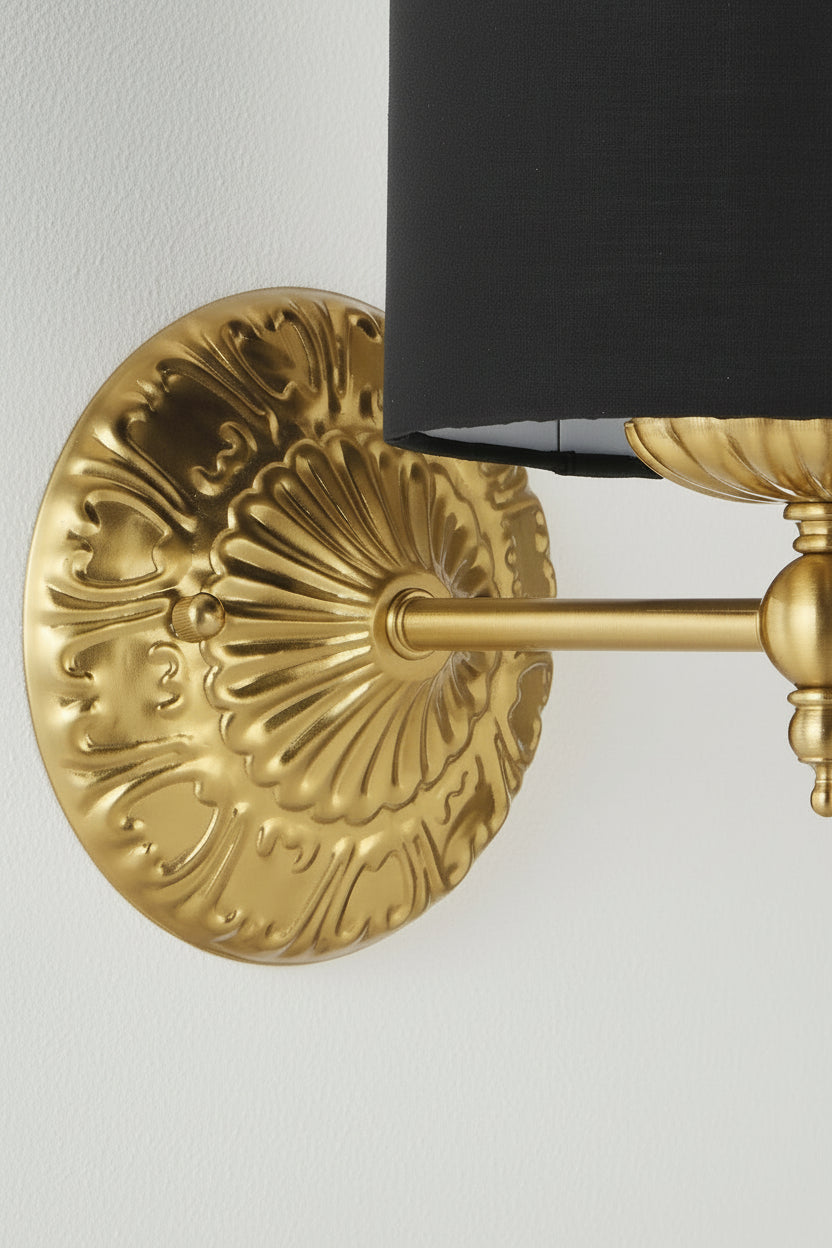 Close up of the antique gold finished wall sconce with heritage detailing.